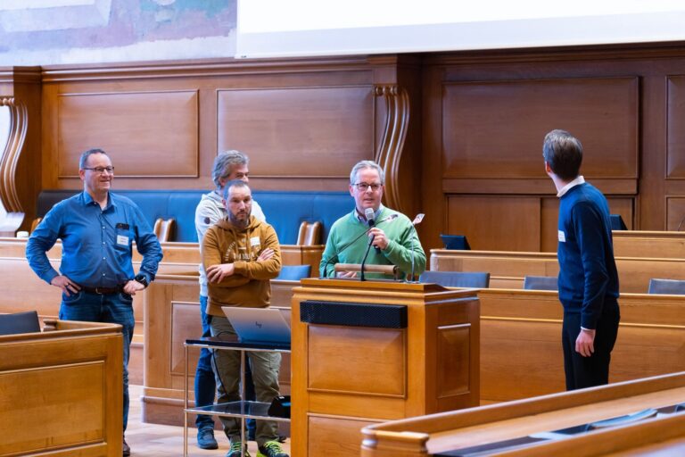 A team presents at the lectern in the Grossrat chamber