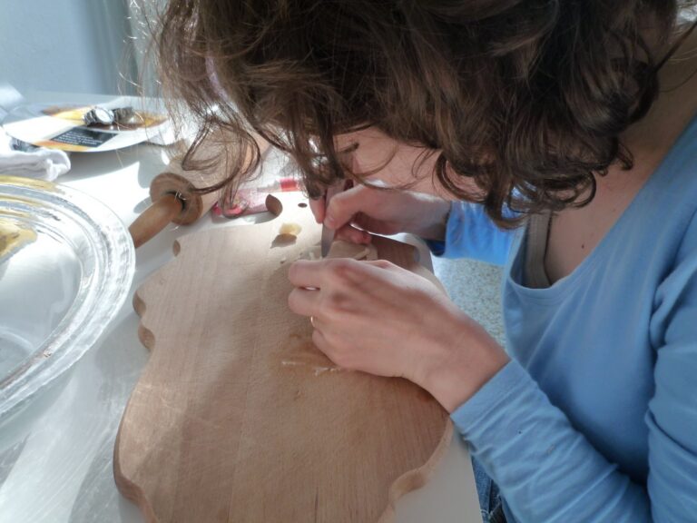 Eine Person modelliert Marzipanfiguren für die Torte