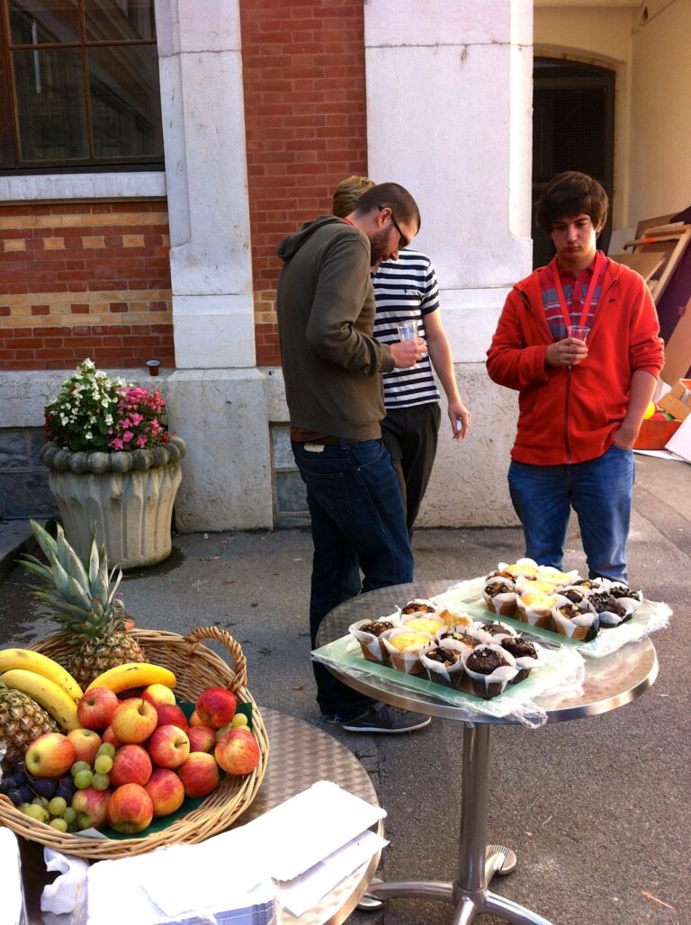 Two participants by an outdoor buffet with fruit