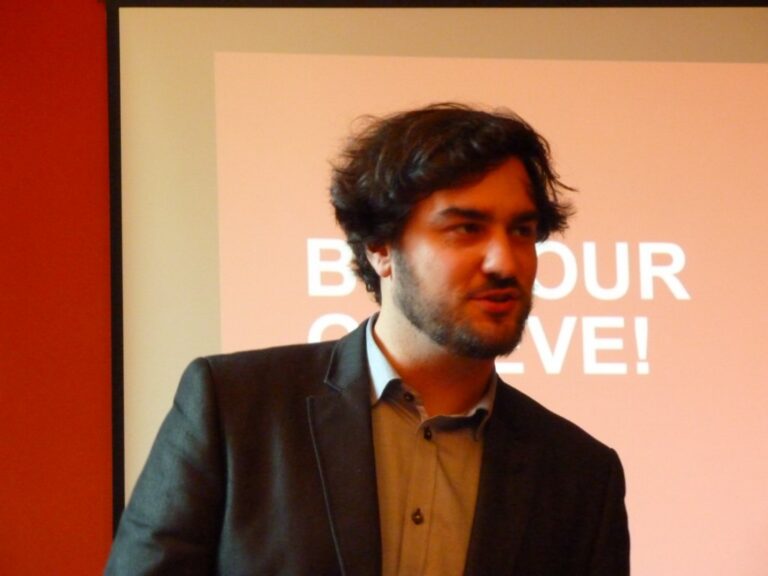 Speaker in front of a slide «Bonjour Genève»
