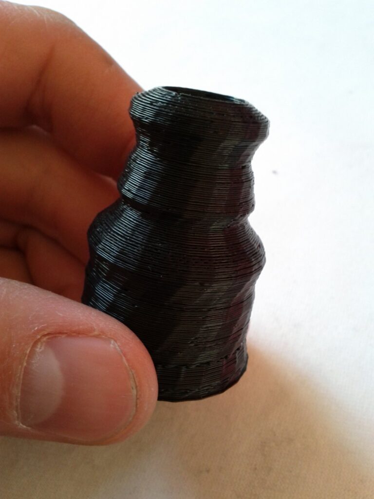 Hand hält eine schwarze Figur aus dem 3D-Drucker