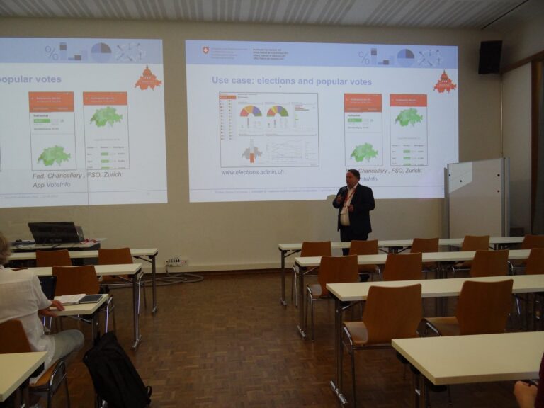 Thomas Schulz in front of two screens showing maps of Switzerland