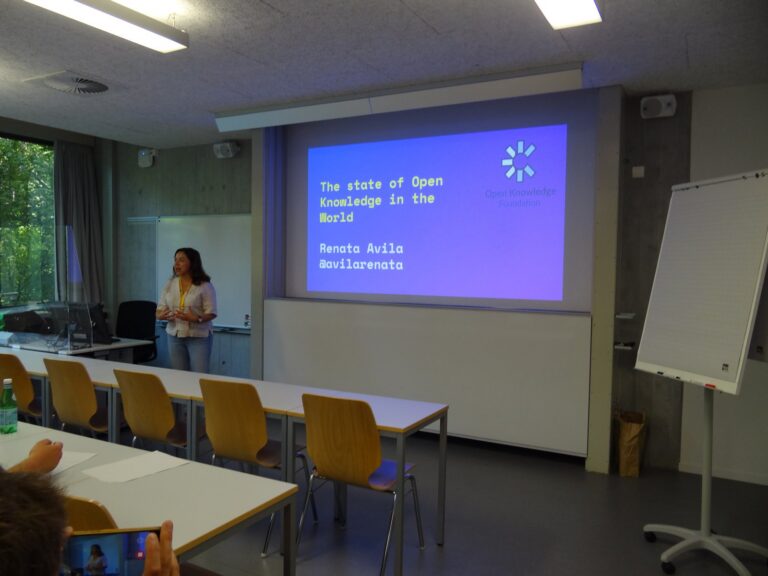 Renata Ávila in front of the slide «The state of Open Knowledge in the World»
