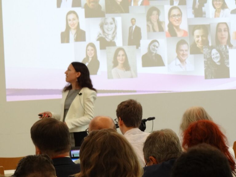Melanie Einsiedler in front of a slide with team portraits