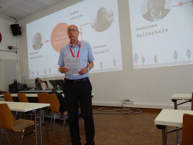 Speaker with notes in front of a slide with portraits