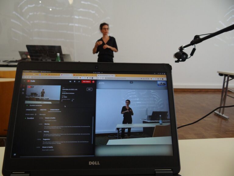 Angela Müller at the front, a laptop with the livestream in the foreground