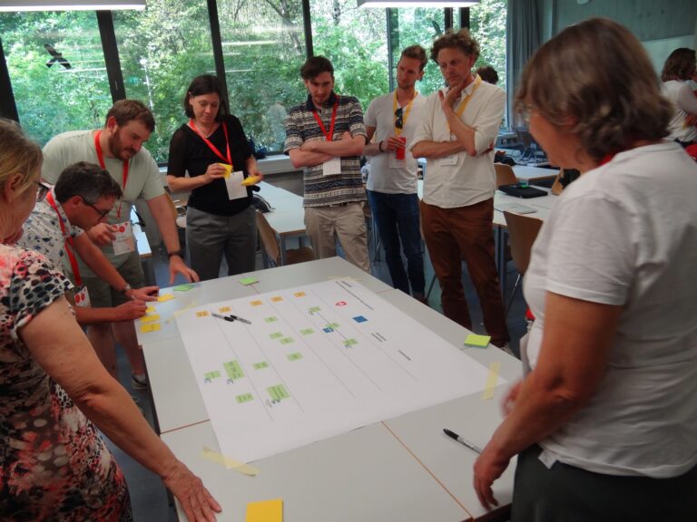 Participants leaning over a table with sticky notes