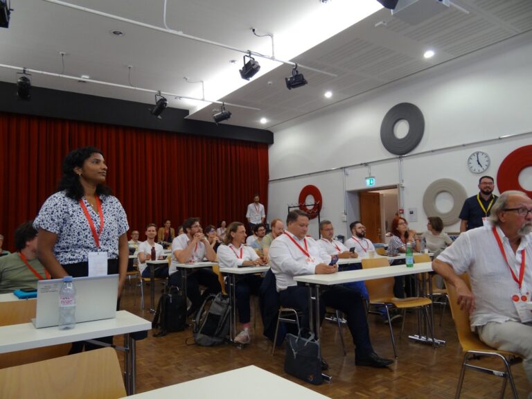 A woman stands in the audience asking a question